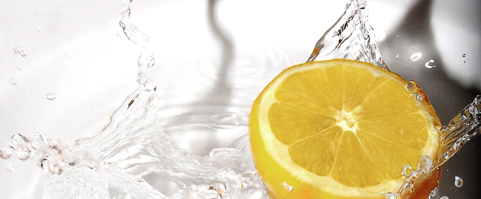 Spritzendes Wasser mit einer Zitronenhälfte